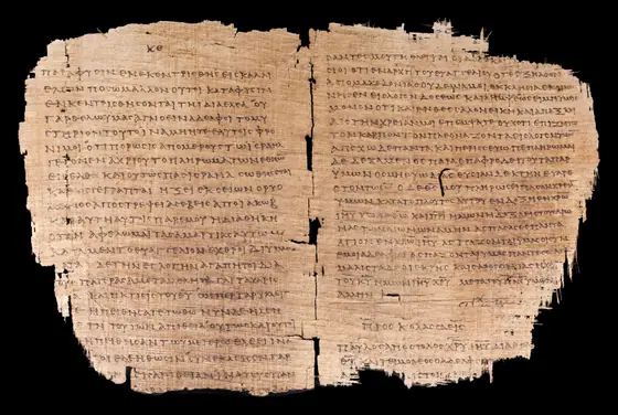 The open Papyrus 46 bifolio — the oldest surviving copy of Paul’s letters, around AD 200. Its left page carries Romans 11 in Greek uncial; the same physical leaf also preserves the end of Philippians and the start of Colossians. Faded brown ink on darkened papyrus.